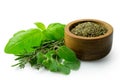 Dried chopped provence herbs in a dark wood bowl next to fresh bouquet garni isolated on white Royalty Free Stock Photo