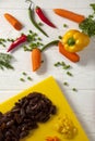 Chopped yellow peppers and carrots. Yellow chopping board and red knife. Green pepper, red hot Royalty Free Stock Photo