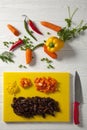 Chopped yellow peppers and carrots. Yellow chopping board and red knife. Green pepper, red hot Royalty Free Stock Photo