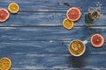 Dried citrus slices with cup of tea on the blue wooden table, top view. Copy space