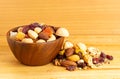 Dried colorful breakfast mix nuts and fruit in wooden bowl and pile on wooden board Royalty Free Stock Photo