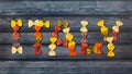 Dried colorful Italian pasta farfalle or bows shaped letters Royalty Free Stock Photo