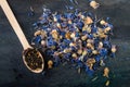 Dried cornflower and tea leaves on wooden spoon