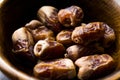 Dried date palm fruits or kurma, ramadan ramazan Medjool food in wooden bowl.