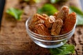 Dried dates in bowl. Dried Raw Organic Medjool date fruit and green mint in a  bowl on old wooden table close up.   , Royalty Free Stock Photo