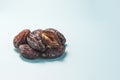 Dried dates close-up on a light blue background of natural light. Royalty Free Stock Photo
