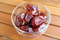 Dried Dates in a Glass Compote on Wooden Table