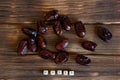 Dried dates lie on a wooden table. Explanatory inscription. View from above.