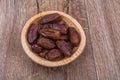 Dried dates in a wooden bowl on a wooden background Royalty Free Stock Photo