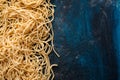Dried egg noodles. Raw Fresh Spaghetti on blue wooden background Royalty Free Stock Photo