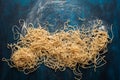 Dried egg noodles. Raw Fresh Spaghetti on blue wooden background Royalty Free Stock Photo