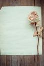 Dried faded roses on old paper on wooden background Royalty Free Stock Photo