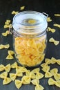 Dried Farfalle Pasta in Glass Jar with Some Scattered Around Royalty Free Stock Photo