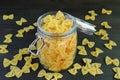 Dried Farfalle Pasta in Glass Jar with Some Scattered Around Royalty Free Stock Photo