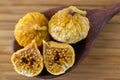 Dried fig fruit cut in half showing seeds on dark wooden spoon on wood