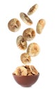 Dried fig fruits falling into bowl on background