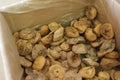 Dried figs in a box on parchment paper for sale.