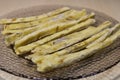 Dried fish straws on a plate on the table.