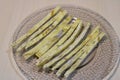 Dried fish straws on a plate on the table.