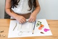 Child with white paper, leaves, and flowers making herbarium on dining wood table in home. Royalty Free Stock Photo