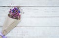 Dried flower bouquet in brown paper on wood background. Royalty Free Stock Photo