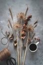 Dried flowers on a dark background. Fall mood flatlay with dried flowers and a cup of coffee