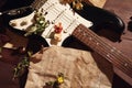 Dried flowers and electric guitar on rare music notes on wooden background closeup Royalty Free Stock Photo