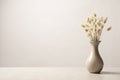 Dried flowers in vase on table against light background. Space for text Royalty Free Stock Photo