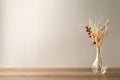 Dried flowers in vase on table against light background. Space for text Royalty Free Stock Photo