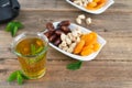 Dried fruit tray with dates, pistachios and dried apricots with tea glass on wooden bottom. Royalty Free Stock Photo