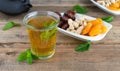 Dried fruit tray with tea glass with mint leaves on wooden background. Copy space Royalty Free Stock Photo