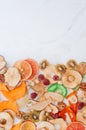 Dried fruit and vegetable chips, candied pumpkin slices, nuts and seeds on white marble background with copy space Royalty Free Stock Photo