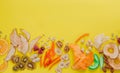 Dried fruit and vegetable chips, candied pumpkin slices, nuts and seeds on yellow background with copy space Royalty Free Stock Photo