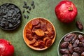 Dried fruits, apricots, raisins, dates and ripe red pomegranates top view in close-up on a green background Royalty Free Stock Photo