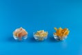 Dried fruits in assortment in glass cups on a blue background. The concept of a healthy lifestyle