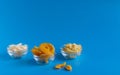 Dried fruits in assortment in glass cups on a blue background. The concept of a healthy lifestyle