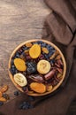 Dried fruits bowl. Healthy food snack: sun dried organic mix of apricots, figs, raisins, dates and other on wooden table, top view Royalty Free Stock Photo