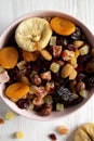 Dried fruits and nut mix in a pink bowl over white wooden surface top view. Overhead, from above, flat lay. Close-up Royalty Free Stock Photo