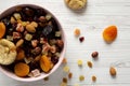Dried fruits and nut mix in a pink bowl on a white wooden table, top view. Overhead, from above, flat lay. Close-up Royalty Free Stock Photo