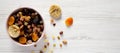 Dried fruits and nuts in a pink bowl over white wooden background. Top view, from above, flat lay. Copy space Royalty Free Stock Photo