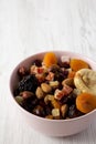 Dried fruits and nuts in a pink bowl over white wooden surface, low angle view. Copy space Royalty Free Stock Photo