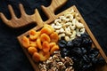 Dried fruits and nuts on a wooden board on a dark background Royalty Free Stock Photo