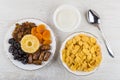Dried fruits in plate, bowls with sour cream, corn flakes Royalty Free Stock Photo