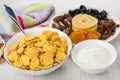 Dried fruits in plate, sour cream, corn flakes and spoon Royalty Free Stock Photo