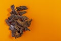 Dried funghi mushrooms isolated on orange background