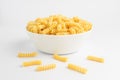 Dried fusili Italian pasta in a round bowl ready to be cooked, isolated on a white table, with side view