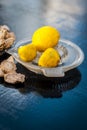 Dried ginger with lemon and its juice with squeezer on wooden surface.