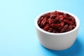 Dried goji berries in bowl on light blue background, closeup. Space for text Royalty Free Stock Photo