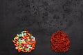 Dried goji berries and colorful capsules on black background. Healthy superfood instead of drugs. Alternative medicine Royalty Free Stock Photo