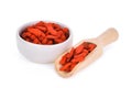 Dried goji berries in wooden scoop and white bowl isolated Royalty Free Stock Photo